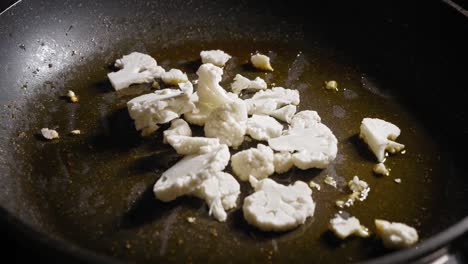 saltear la coliflor picada en una sartén con mantequilla