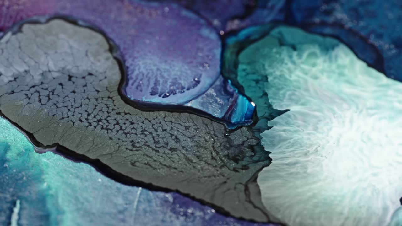 Close-up of vibrant blue and purple ink spreading in water with abstract patterns