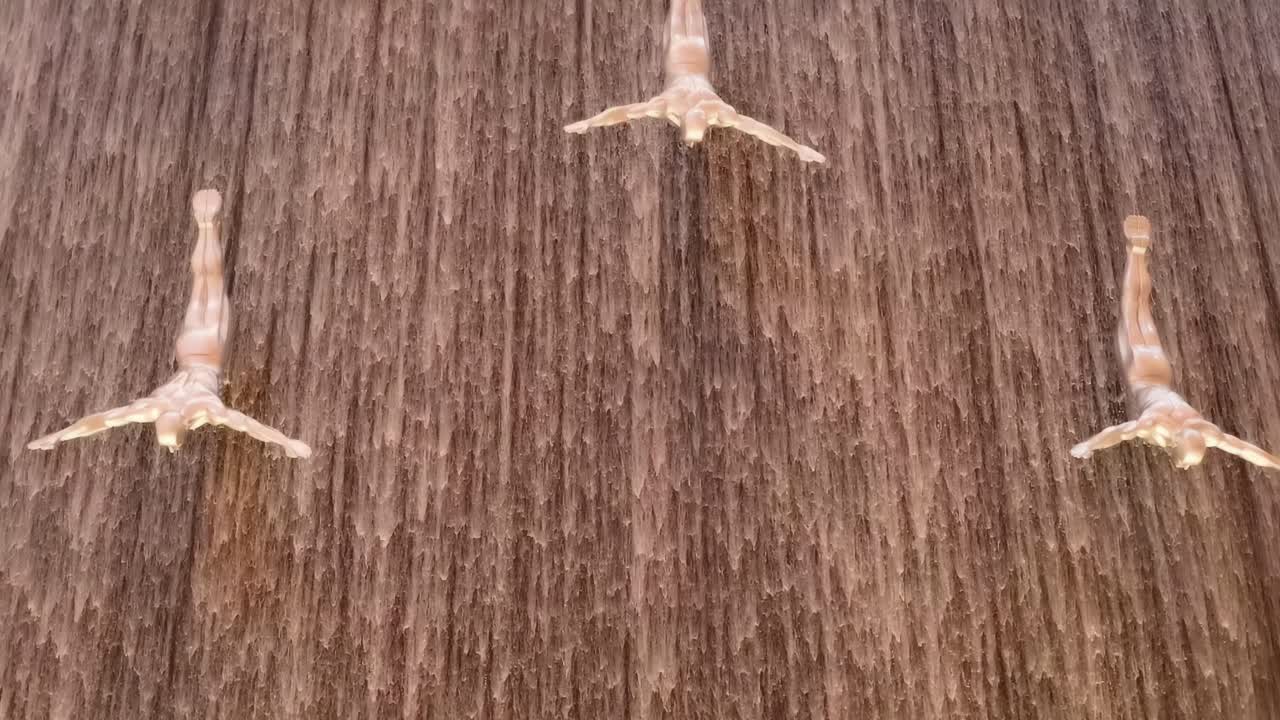 방문객 들 은 다이빙 조각품 을 가진 폭포 를 감상 한다