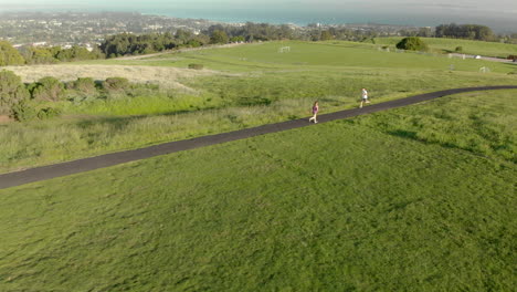 aerial of young woman running on a track at sunset