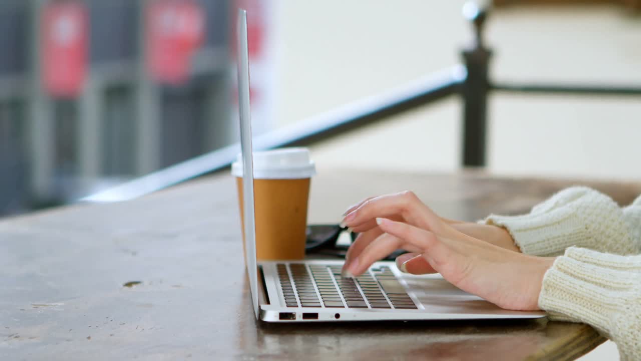 Woman using laptop in cafe 4k