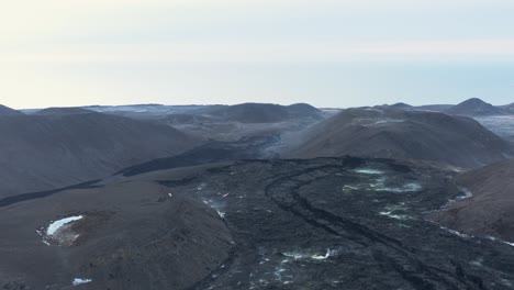 Fagradalsfjall-valley-with-large-stream-of-solid-black-lava-from-Geldingadalsgos-eruption,-aerial