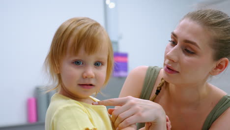 loving mother and young daughter share heartfelt moment, holding hands in deep connection, child looks at someone with curiosity while mother engages attentively