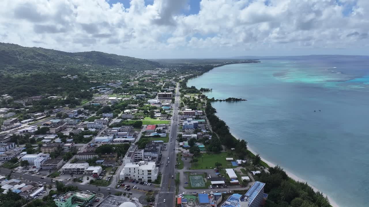 Trace the path of endurance in paradise. This sweeping aerial footage captures the renowned coastal running course along Saipan's west coast, famous for hosting international marathons. Stretching fro