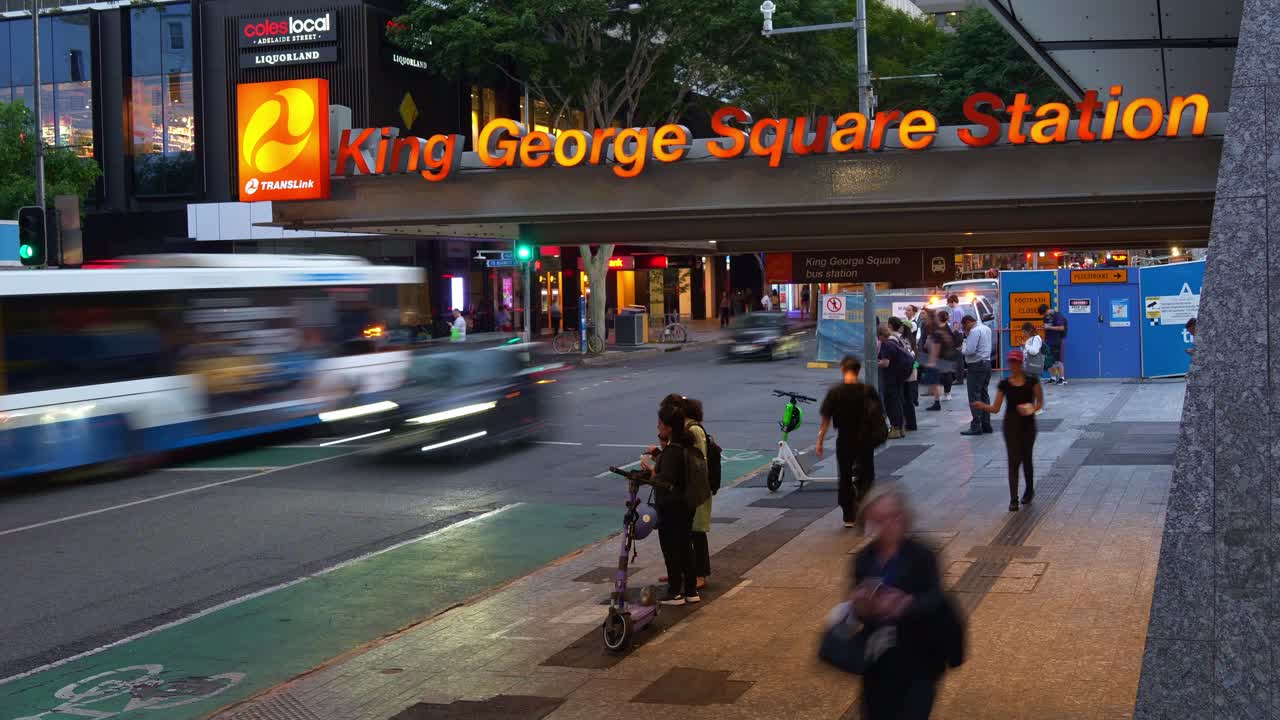 Busy entrance of King George Square Station on Adelaide street during rush hour with pedestrians crossing the crosswalk, buses and cars running along the street, fast motion time-lapse shot.