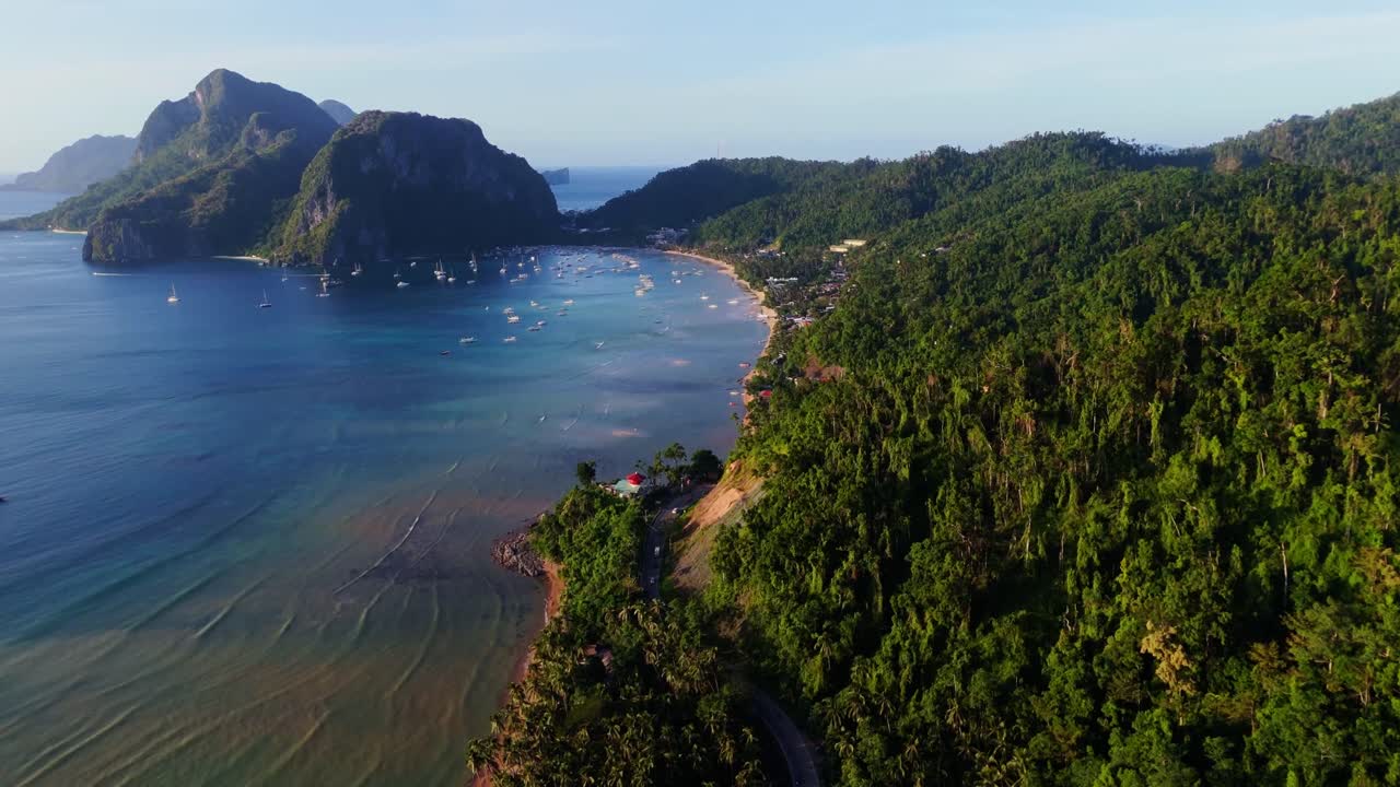 Cảnh panorama từ flycam những ngọn đồi xanh tươi nhìn ra vịnh El Nido màu ngọc lam. Với những vách đá vôi mang tính biểu tượng và nhiều thuyền tại đảo Palawan, Philippines.