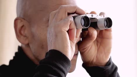 binoculares mirando a través de binoculares con fondo blanco almacen de metraje de video