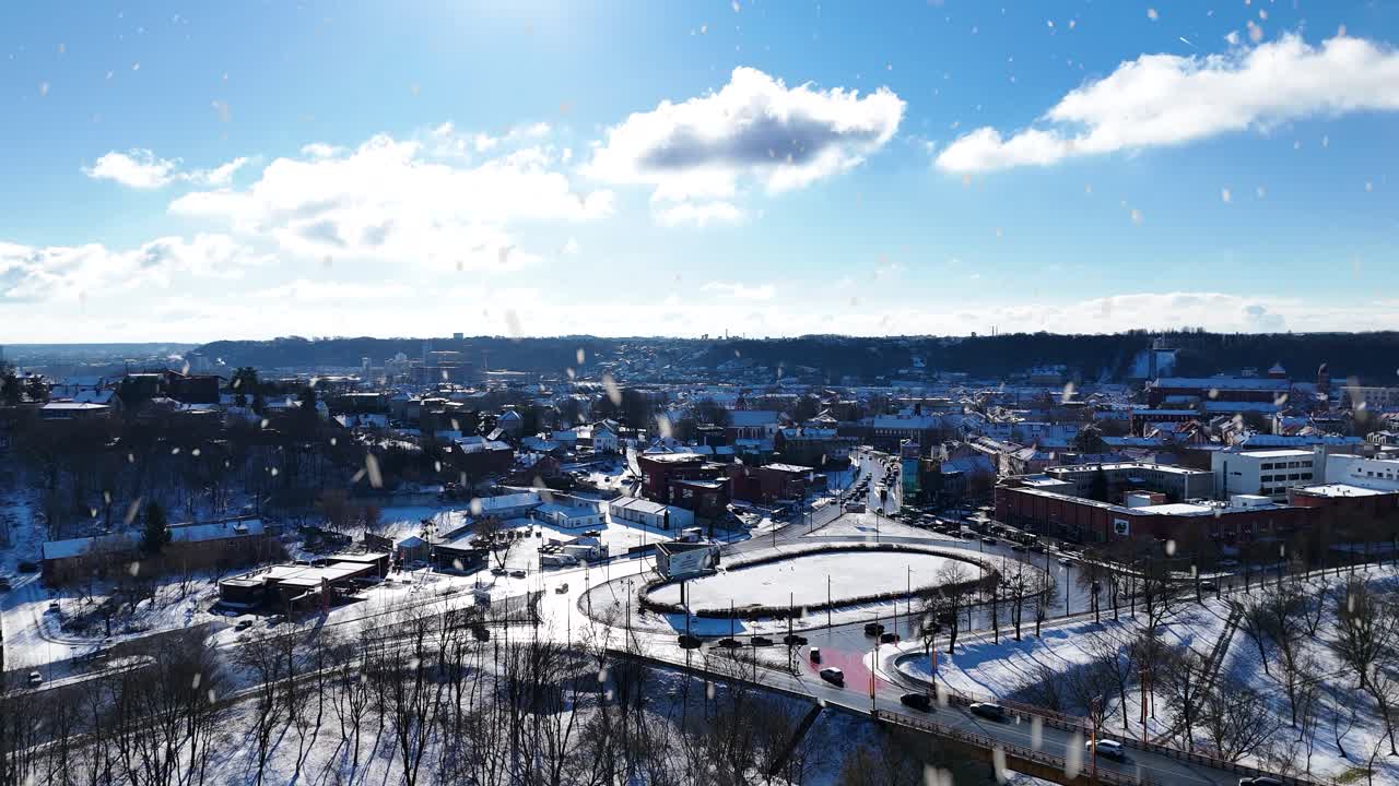 Kaunas downtown and bridge with roundabout during snowfall, aerial view