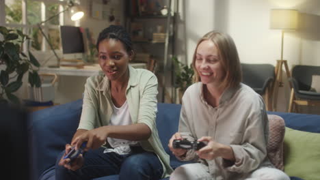 two women friends enjoying a video game session on the couch