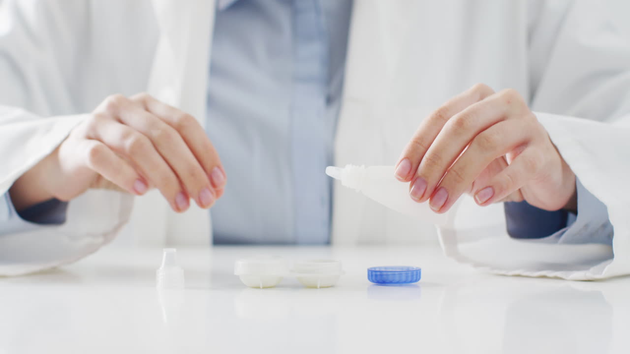 백인 의사가 콘택트 렌즈 케이스에 렌즈 용액을 넣는 중간 부분의 비디오