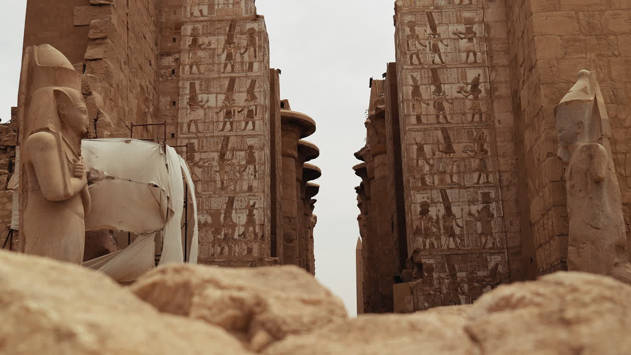 Massive stone pillars and hieroglyph-covered walls inside Karnak Temple in Luxor, Egypt. Iconic ruins of ancient Egyptian history and culture