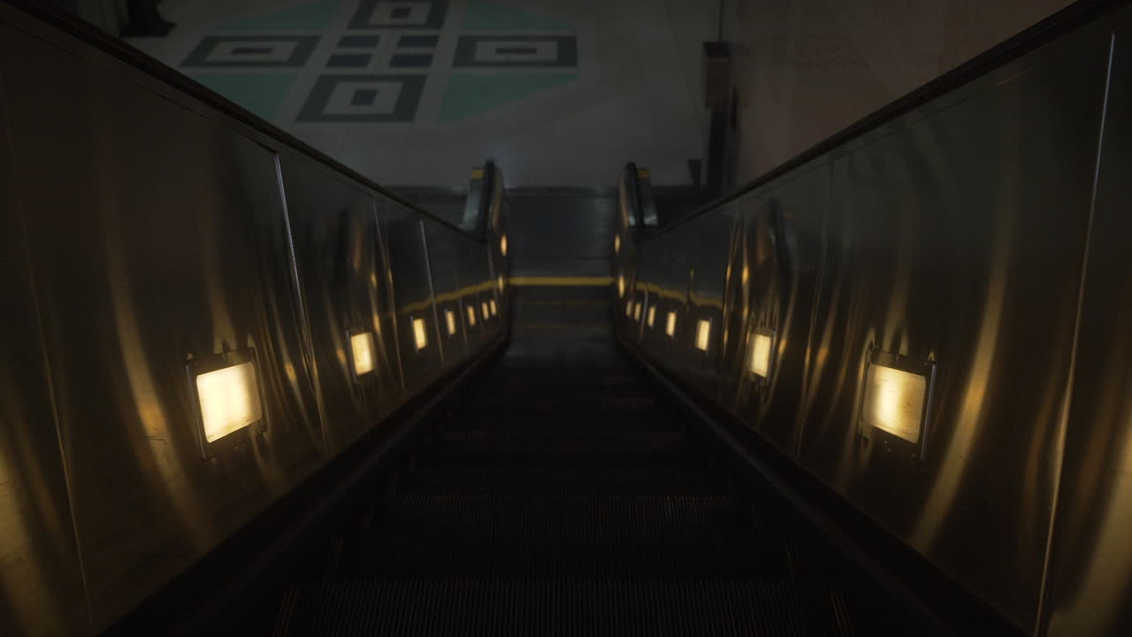 지하철 역에서 어두운 에스컬레이터를 내려가고