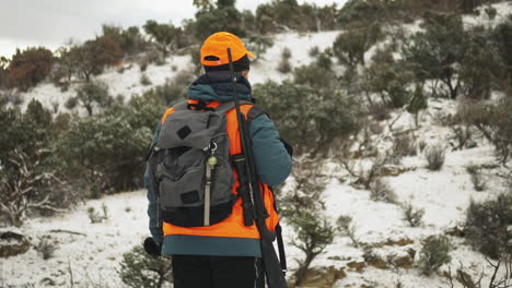 Cazador-Mirando-Un-Desierto-De-Matorrales-Nevados-Preparándose-Para-Apuntar