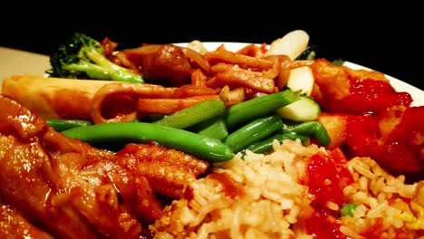 Nahaufnahme-Chinesisches-Essen-Authentisches-Sortiment-Aus-Hähnchen-Rindfleischgemüse-Auf-Reis-Mit-Schmackhaften-Saucen-Rotiert-Auf-Einer-Weißen-Pastete-Auf-Einer-Holzoberfläche-Mit-Dunklem-Hintergrund-Glänzendes-Saftiges-Essen-In-Leuchtenden-Farben-Yum