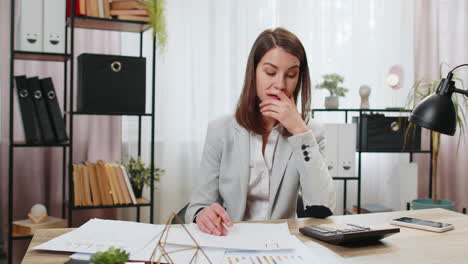 Depressed-desperate-businesswoman-feeling-worried-about-financial-problem-doing-paperwork-at-office