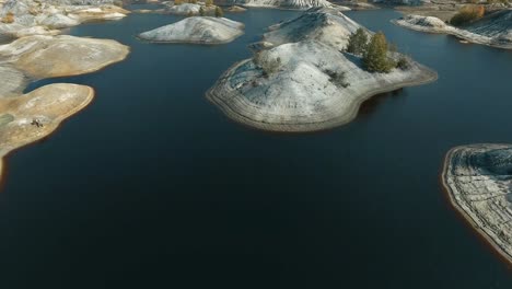 aerial view of a quarry landscape with water filled pits and hills