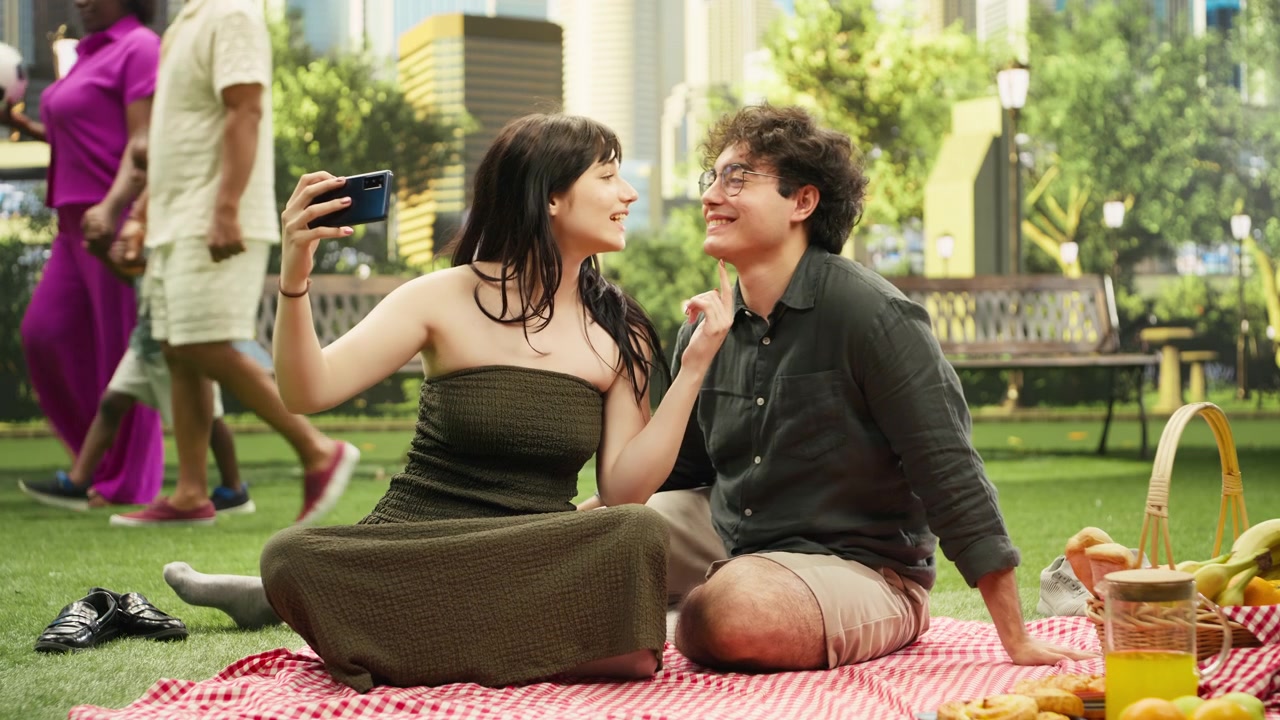 Playful young couple makes silly faces for smartphone selfies in city park