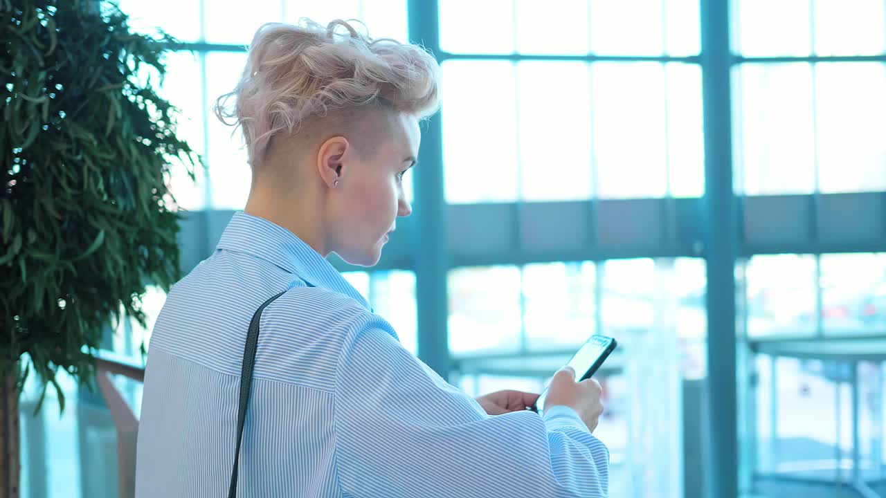 쇼핑몰에서 스마트폰을 사용하는 여성