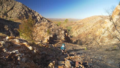 Hiker-climbs-stairs-towards-camera-through-rugged-Australian-landscape