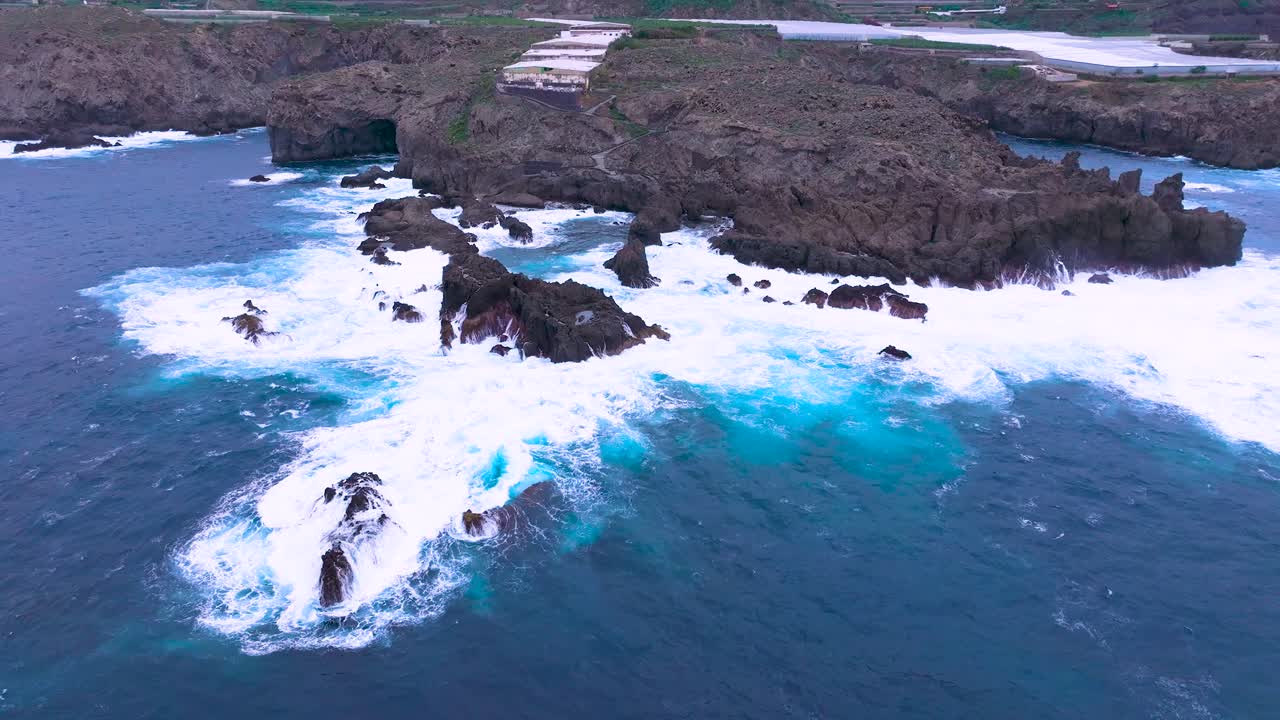 Aerial view of rugged Charco del Viento pools and choppy sea in Tenerife
