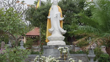 white statue of the deity quan am at the front of van son pagoda in con dao island, vietnam