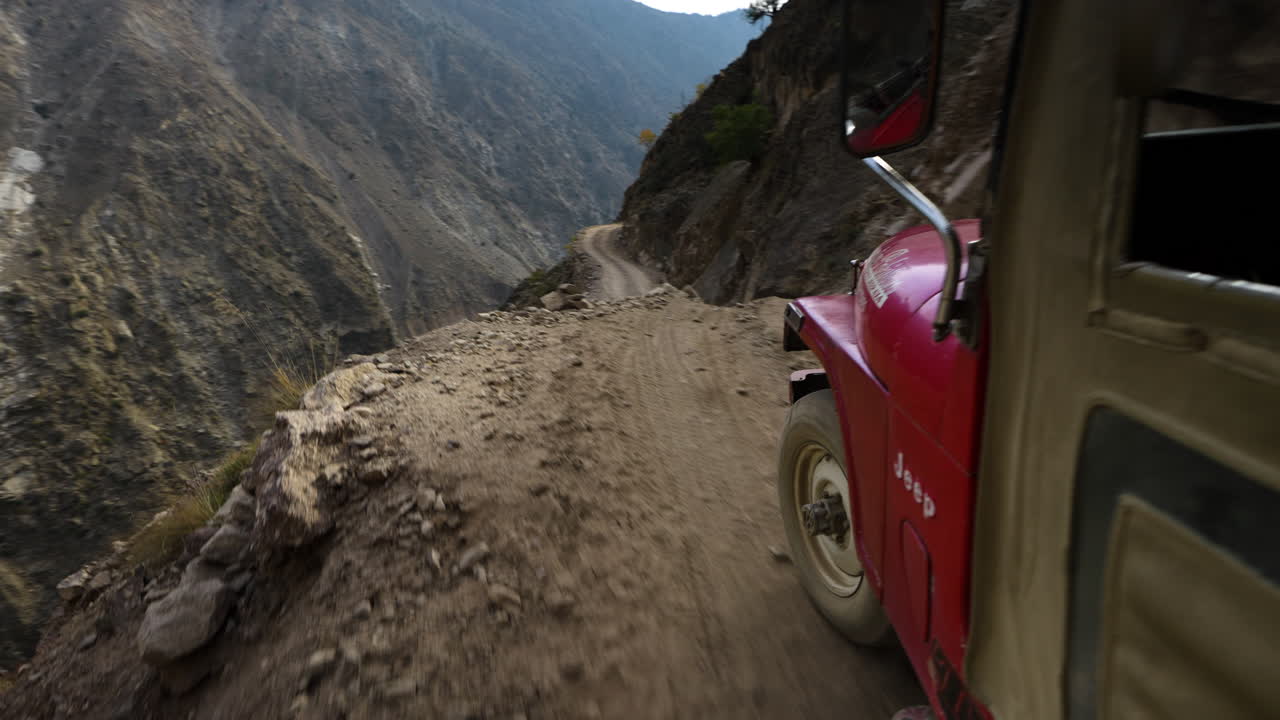 파키스탄의 길기트-발티스탄 지역에 있는 페어리 메도우 도로에서 위험한 높은 산길을 여행하는 오래된 지프의 전망