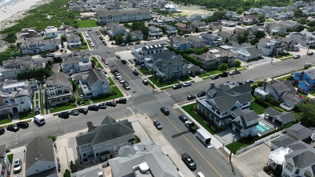 Black on street of stone harbor beach city in New Jersey. Sandy beach and luxury villas and homes in small town of USA. Sunny day in summer. Aerial tracking shot
