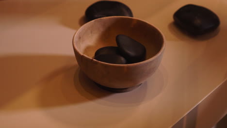 heating up massage stones on a wooden cup