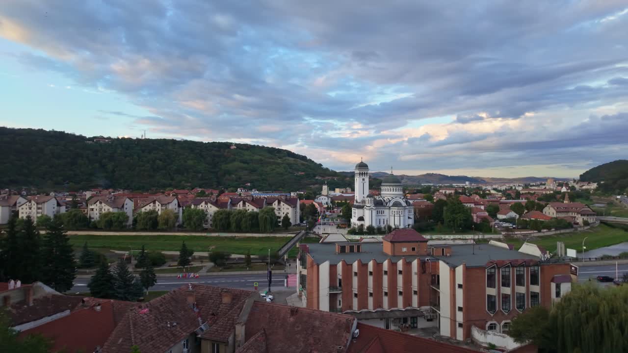 Panoramic cityscape with the Holy Trinity Orthodox Church and surrounding green hills in Sighișoara, Romania