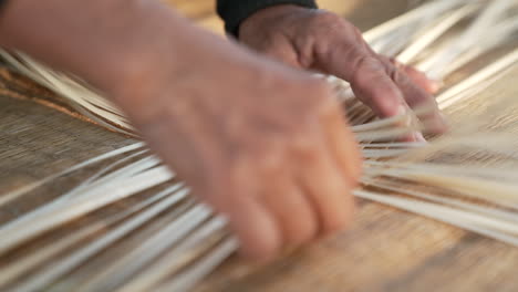 traditional asian bamboo weaving by hand, interlacing strips of bamboo creating a bamboo mat