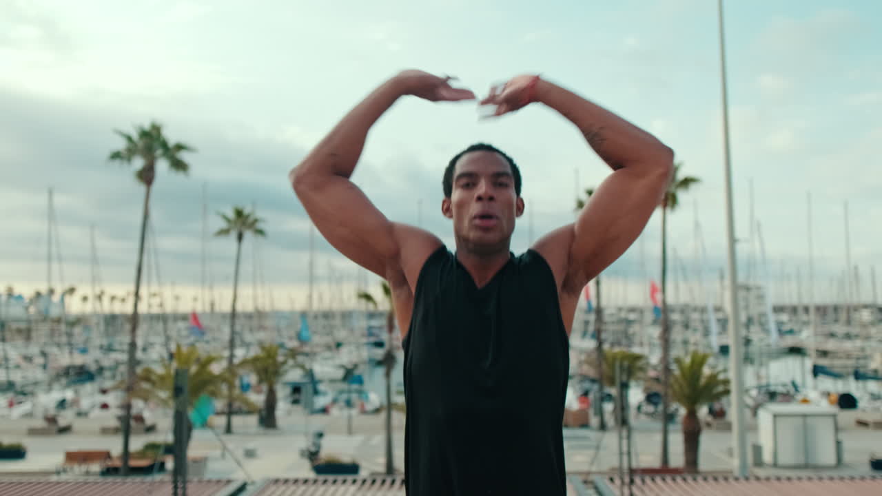 Fit Black Man Doing Jumping Jacks by the Marina