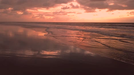 stunning drone shot of waves and beach in sunrise, brazil