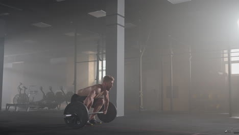 slow motion: man doing deadlift exercise at gym