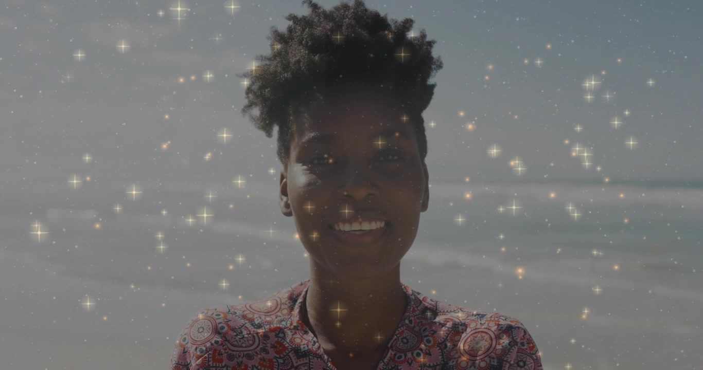Woman standing at shore seeing drifting stars and pivoting head to camera showing joy for marketing