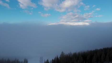 Reveals-the-mountain-above-the-forest-and-fog,-in-Trysil,Norway