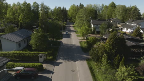 aerial view flying low over a neighborhood street, spring greenery in helsinki