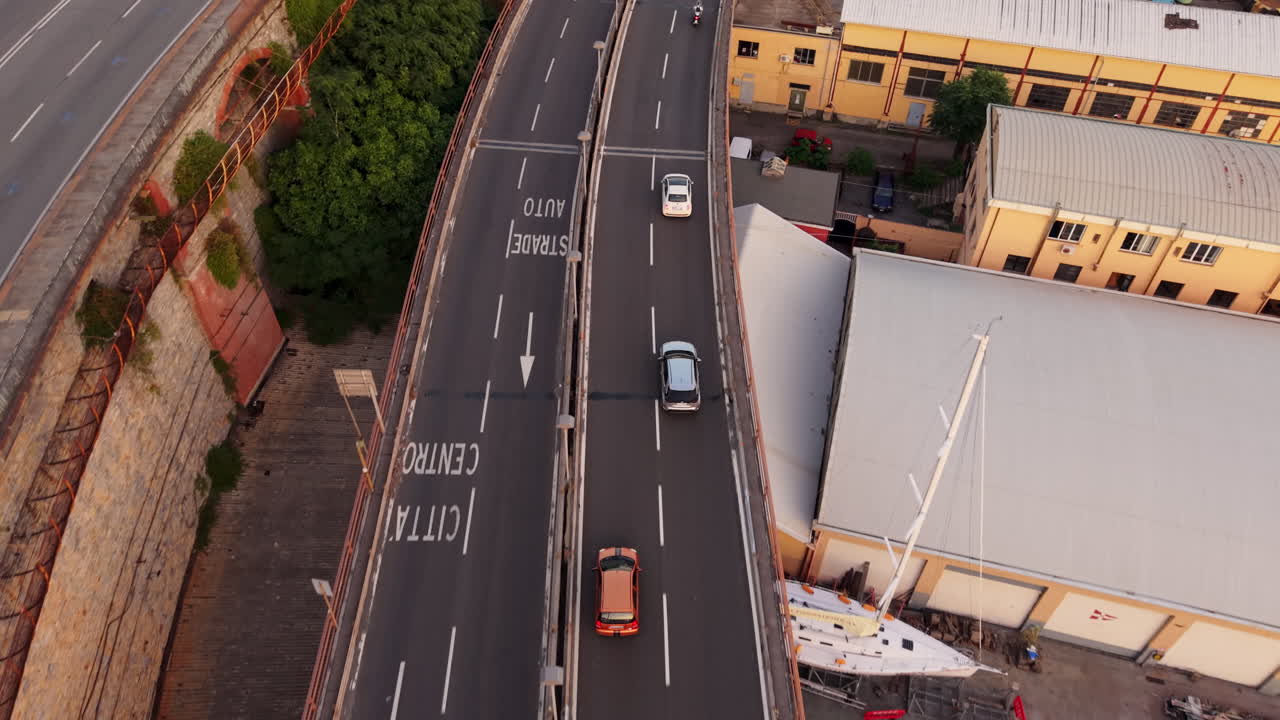 Drone top down view of Genoa, Italy, highway traffic, nearby building and boats docked at port