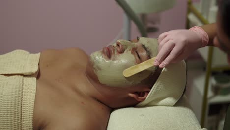 modelo latino mexicano mientras tiene una limpieza profunda hidratante arcilla masaje de terapia facial en el spa wellness center resort