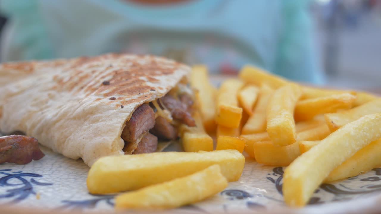 niño comiendo shawarma y papas fritas