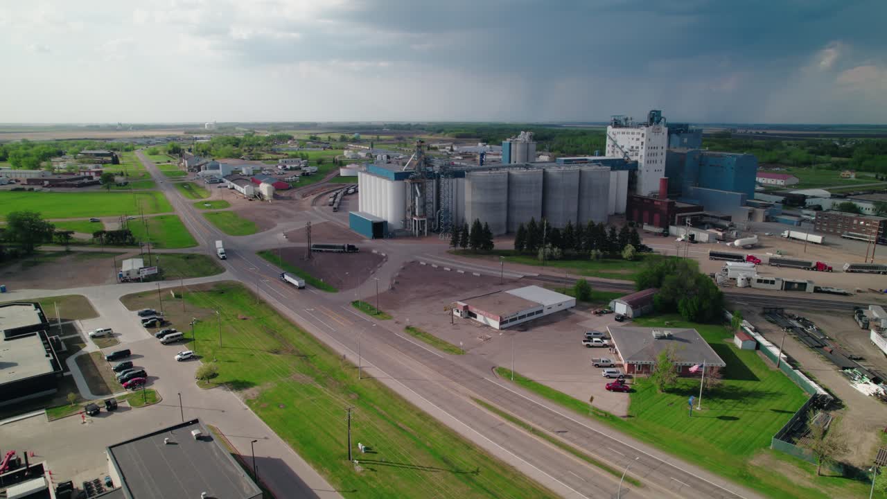Aerial drone shot of a grain elevator and silos along a highway in Fargo, North Dakota, showcasing rural agribusiness infrastructure.