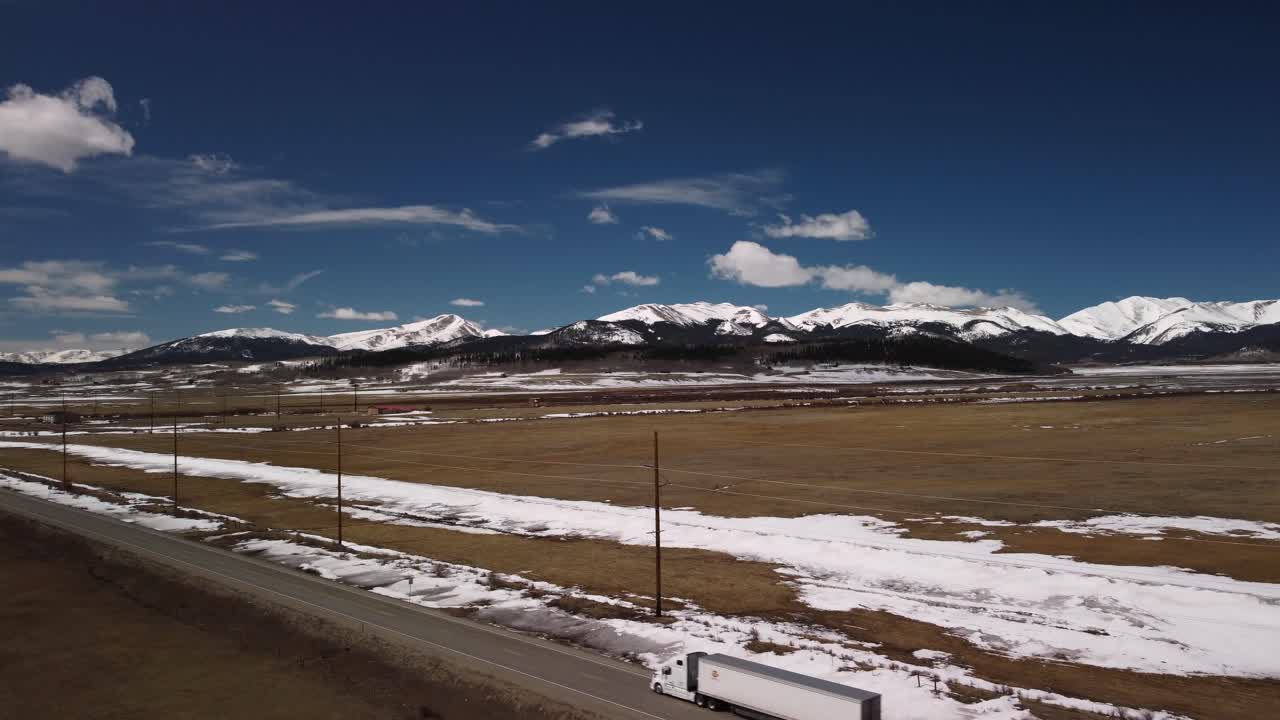 Mountain views driving down Colorado highway during the winter, Aerial Pan