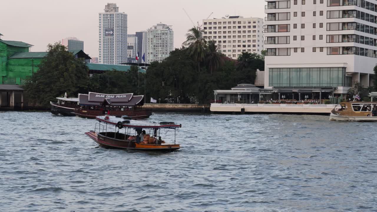 varios barcos moviéndose en un río en un paisaje urbano