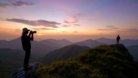 silhouettes on a mountain peak at sunset/sunrise