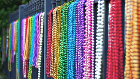 colorful mardi gras beads hanging on iron fence new orleans