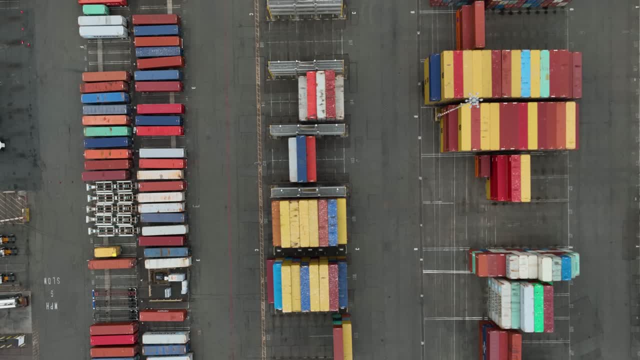 Luftfoto ovenfra af shippingcontainere i en havn, der venter på at blive fragtet rundt om i verden