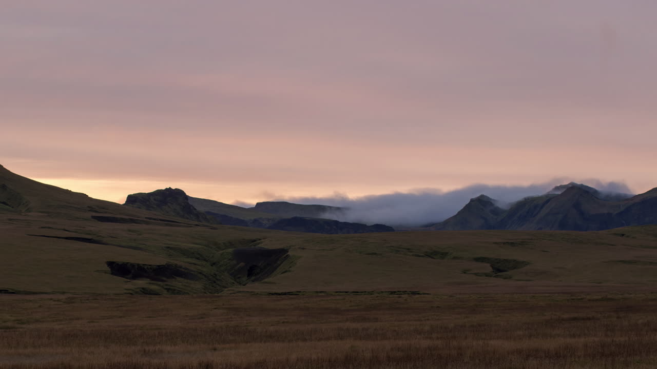 hermosa puesta de sol sobre llanuras cubiertas de hierba y montañas en el sur de islandia