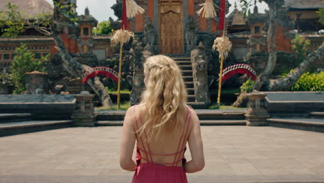 Reisefrau-Erkundet-Den-Saraswati-Tempel-Im-Reiseurlaub-Und-Besichtigt-Die-Schöne-Alte-Kultur-Von-Bali,-Indonesien-4k