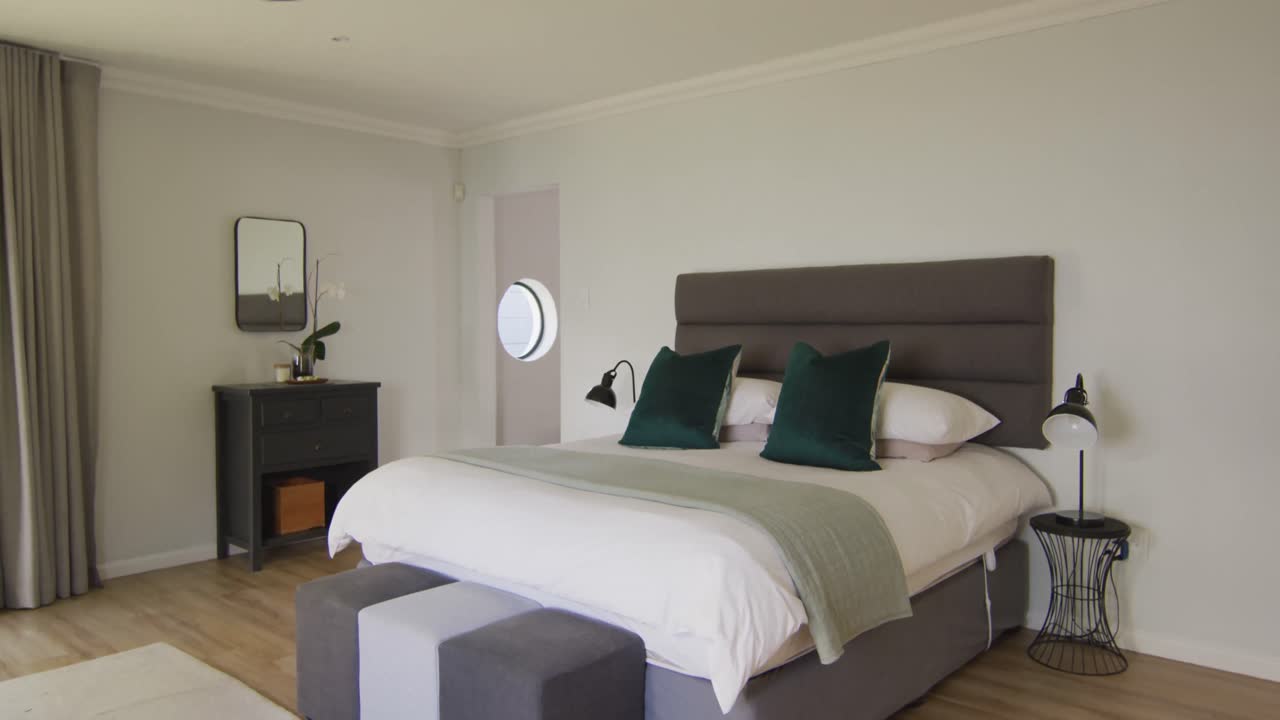 vista general del dormitorio de lujo con cama grande y mesas de noche