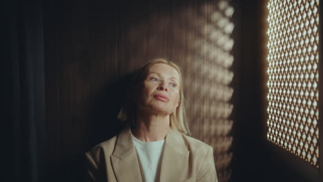 mature woman speaking through latticed opening during confession