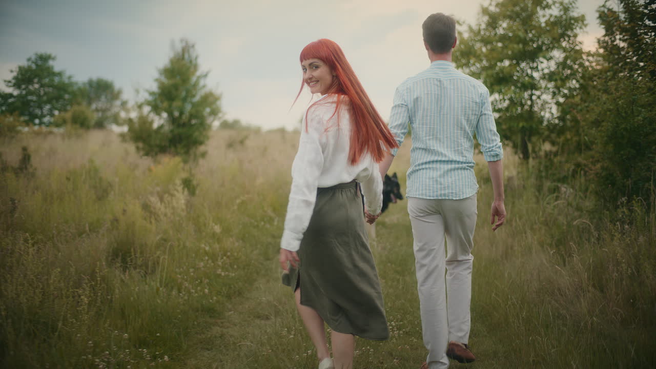 Couple Walking Hand in Hand Through a Meadow